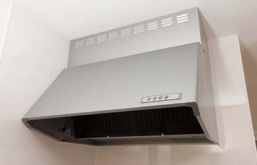 キッチンに設置されたシルバーのレンジフードが壁に取り付けられている様子