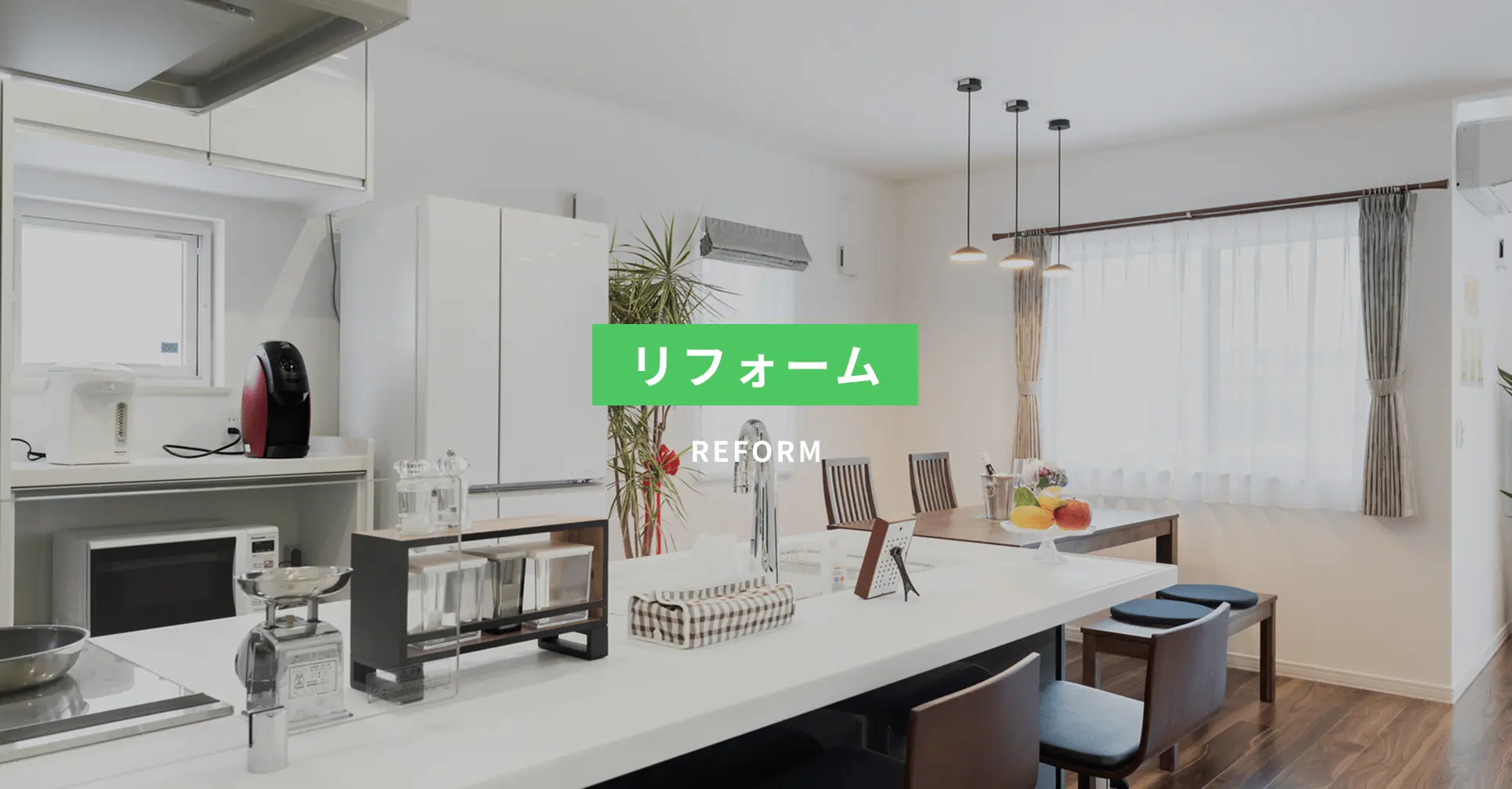 中央に「リフォーム」の文字が表示された、改装後の明るく清潔感のあるキッチンとダイニングの写真